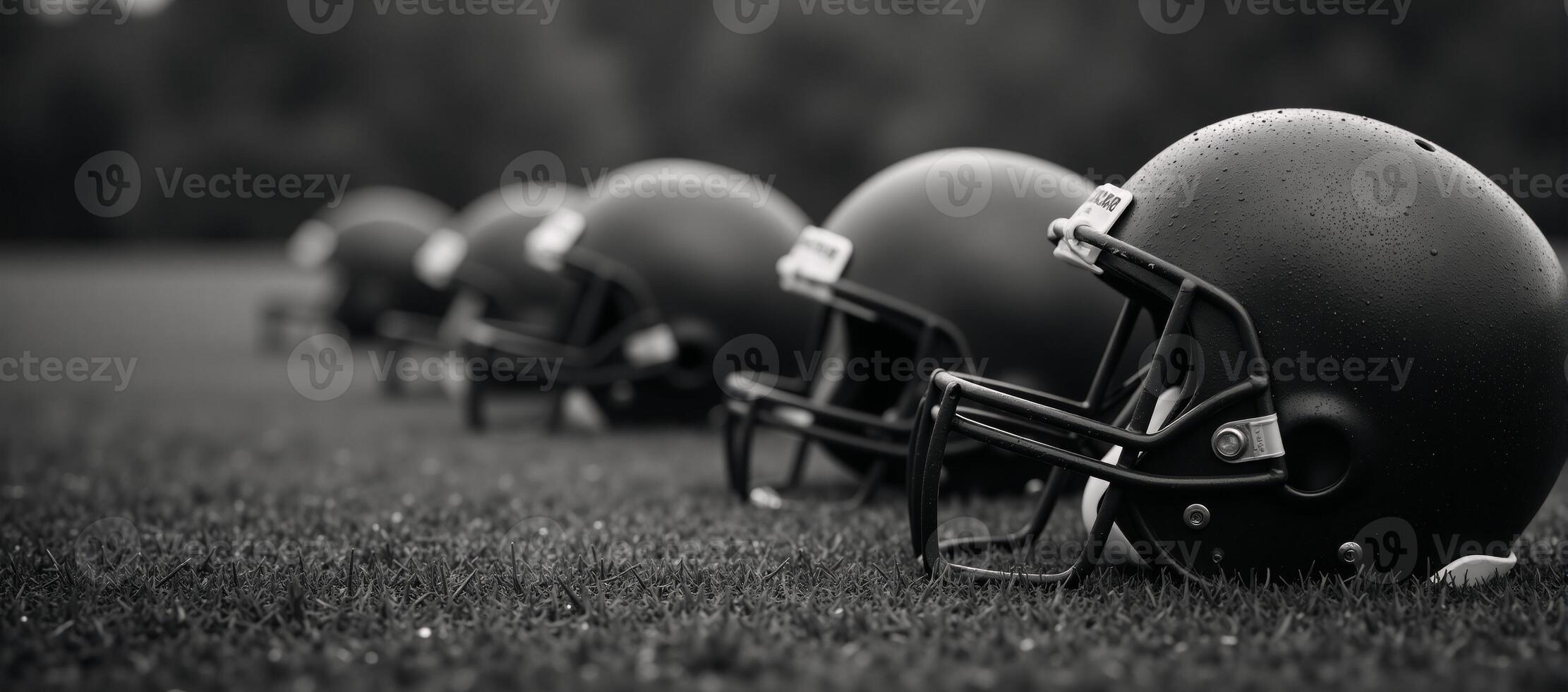 Worn football helmets on rainsoaked field with bokeh light effects photo