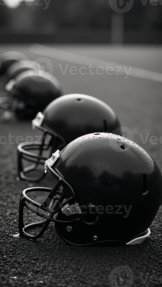 Worn football helmets on rainsoaked field with bokeh light effects photo