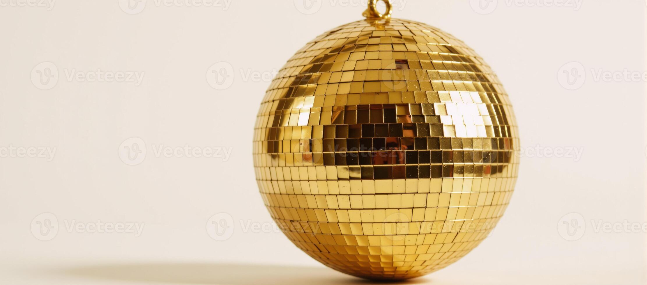 A shimmering gold disco ball against a crisp white backdrop photo