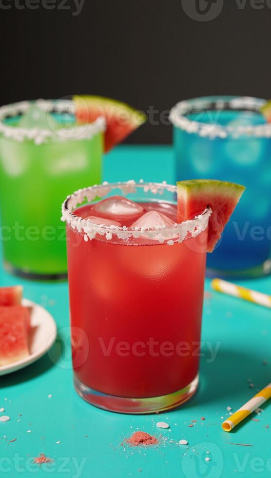 A vibrant closeup image of a red margarita adorned with a watermelon slice against a backdrop of other colorful cocktails set on a festive multicolored tablecloth during a lively party scene photo