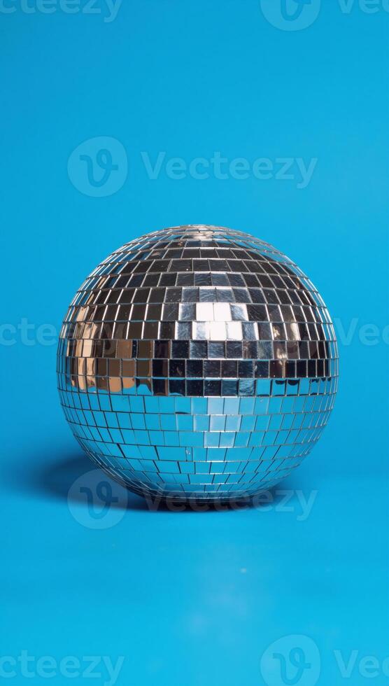 A vibrant disco ball illuminates a lively festive scene with its sparkles against a backdrop of deep blues photo