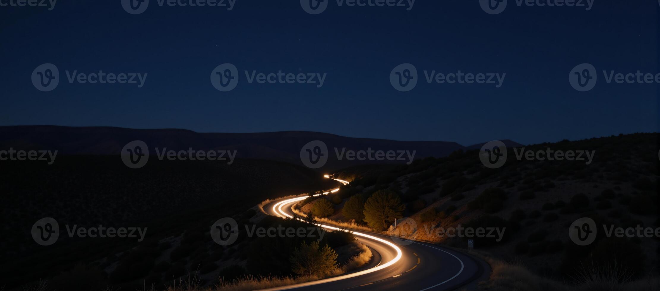 A twilight road with headlightlit curves set amidst a starry night sky photo