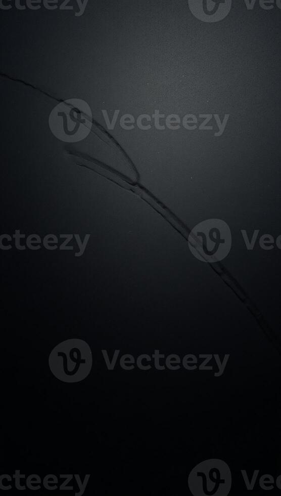 Closeup image showcases intricate patterns on a black metallic surface with seams and rivets photo