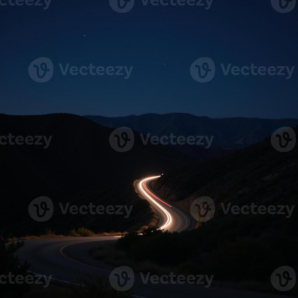A twilight road with headlightlit curves set amidst a starry night sky photo