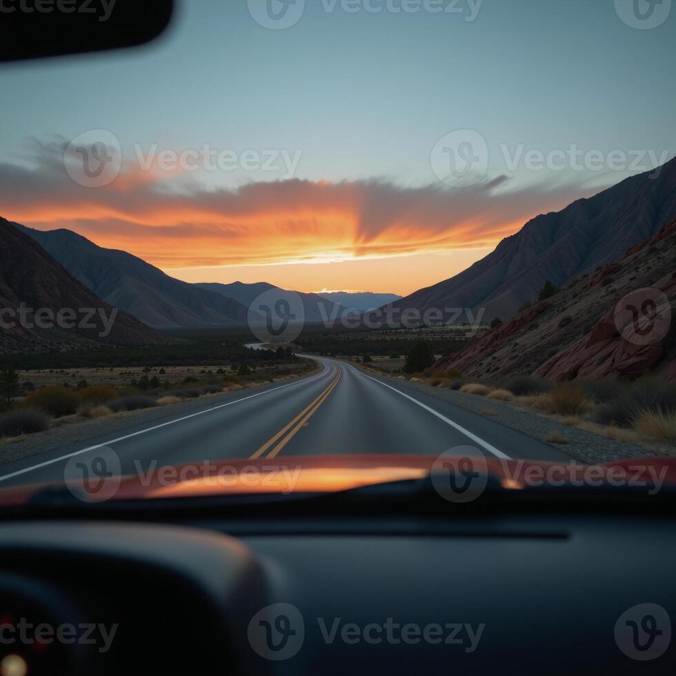 View from a cars rearview mirror featuring the road stretching out behind photo
