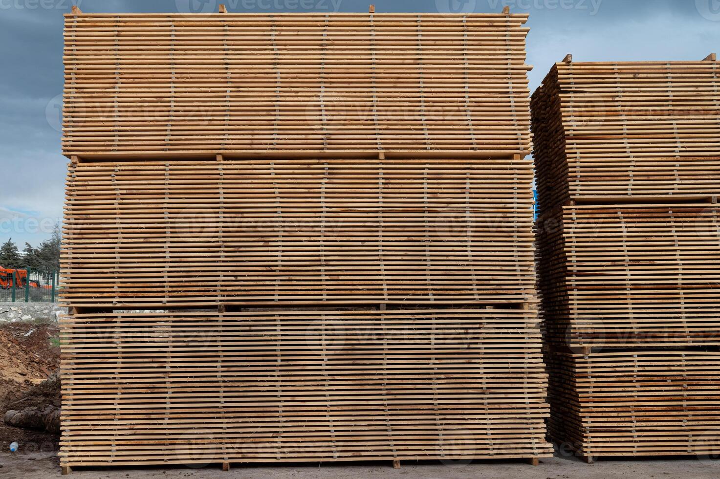 Stacks of boards, board flooring in a sawmill. Warehouse for cutting boards in a sawmill outdoors. Stack of wooden blanks construction material wood timber. Industry. photo