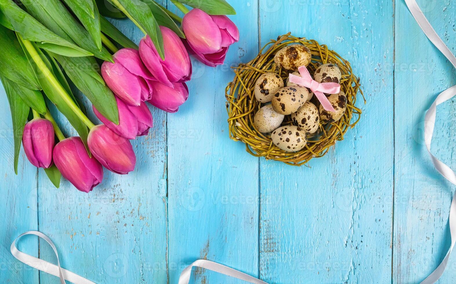 Spring background. Bouquet of flowers on a wooden background and a nest with eggs. spring photo