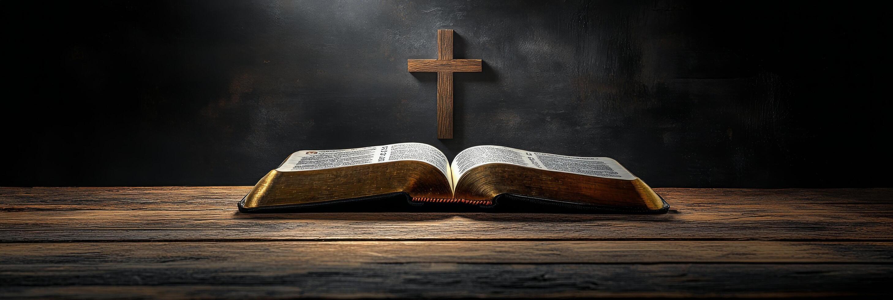 An open Bible resting on a wooden surface with a cross illuminated by soft light photo