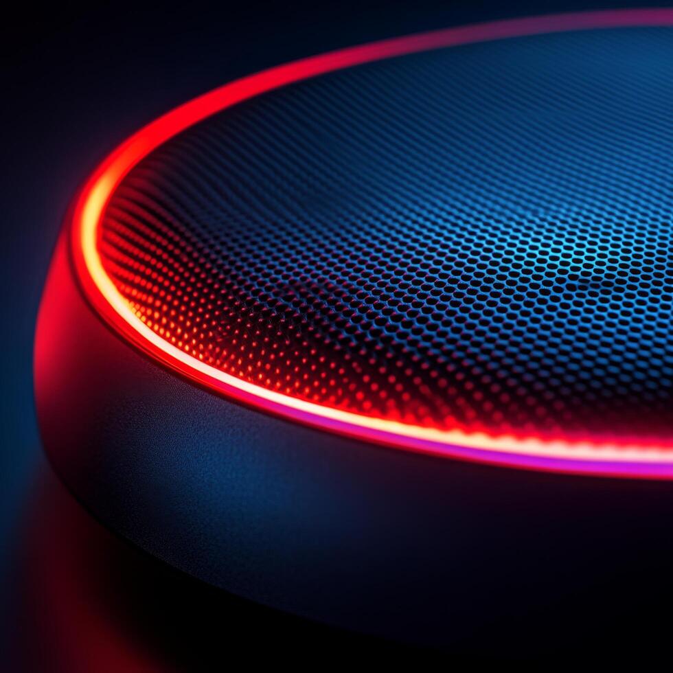 Modern audio speaker illuminated with red and blue lights against a dark background photo
