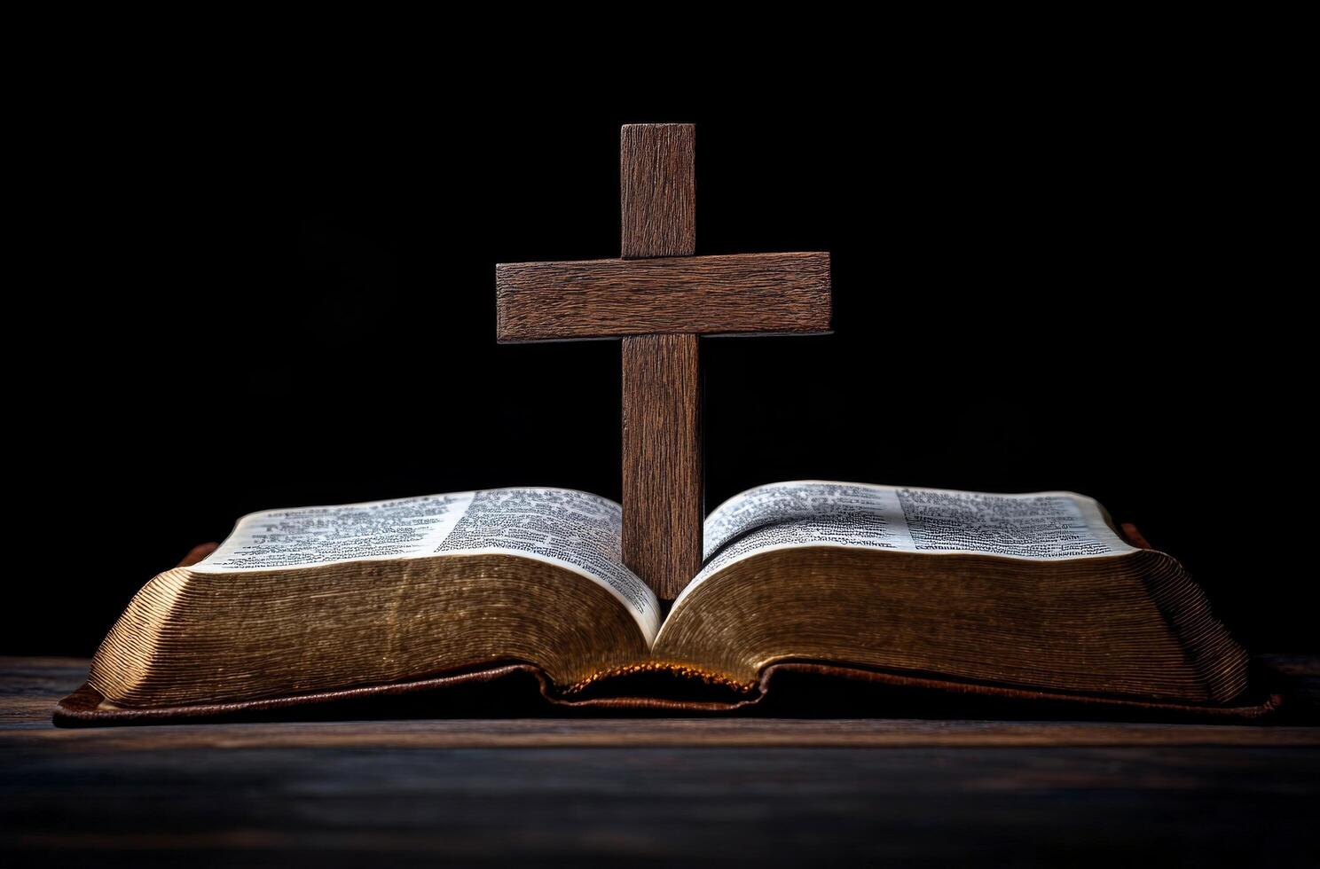 A wooden cross stands on an open Bible in a dimly lit room during evening hours photo