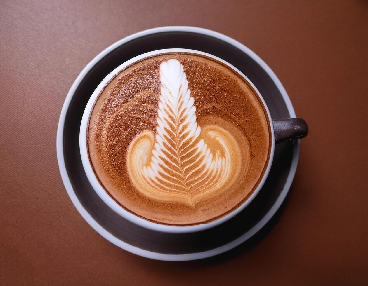 Cappuccino coffee with foam latte art on brown background photo