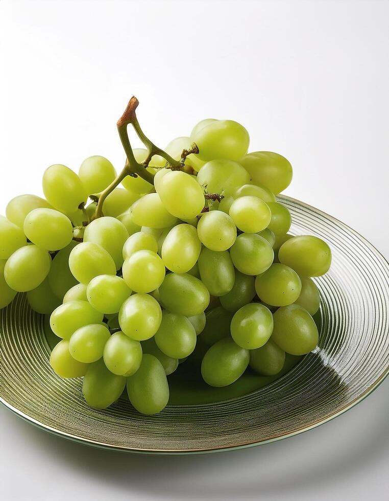 A plate of shiny green grapes on a clean white background photo