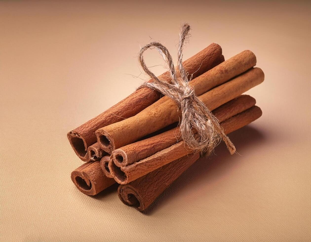 Cinnamon sticks tied with twine on beige background for autumn theme photo