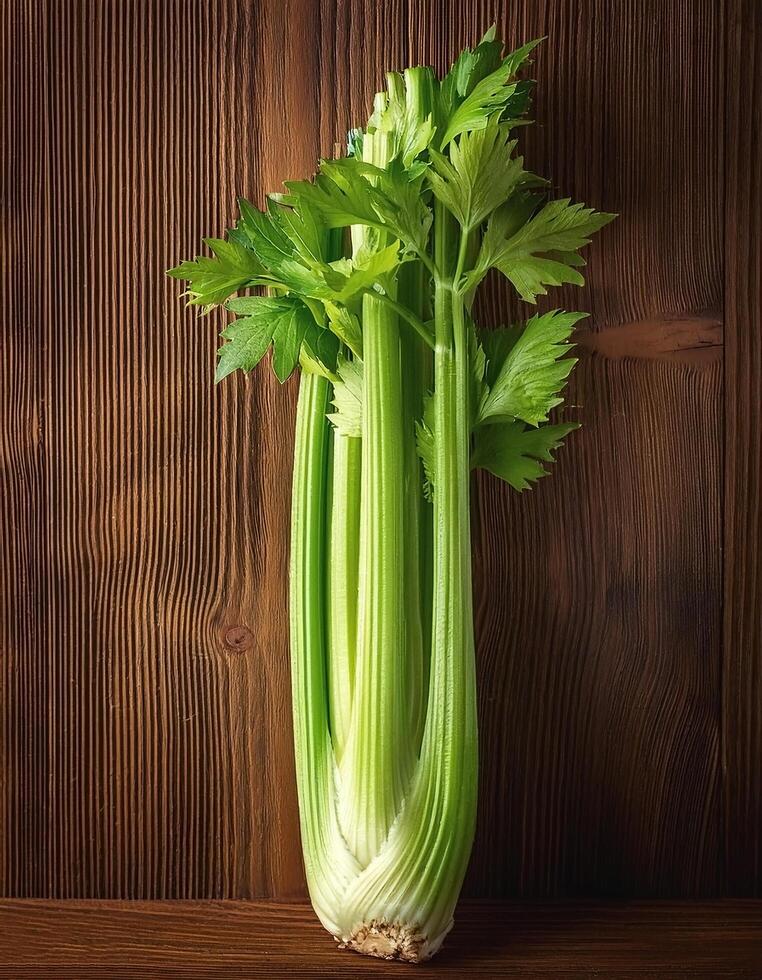A fresh celery stalk on a wooden brown background photo
