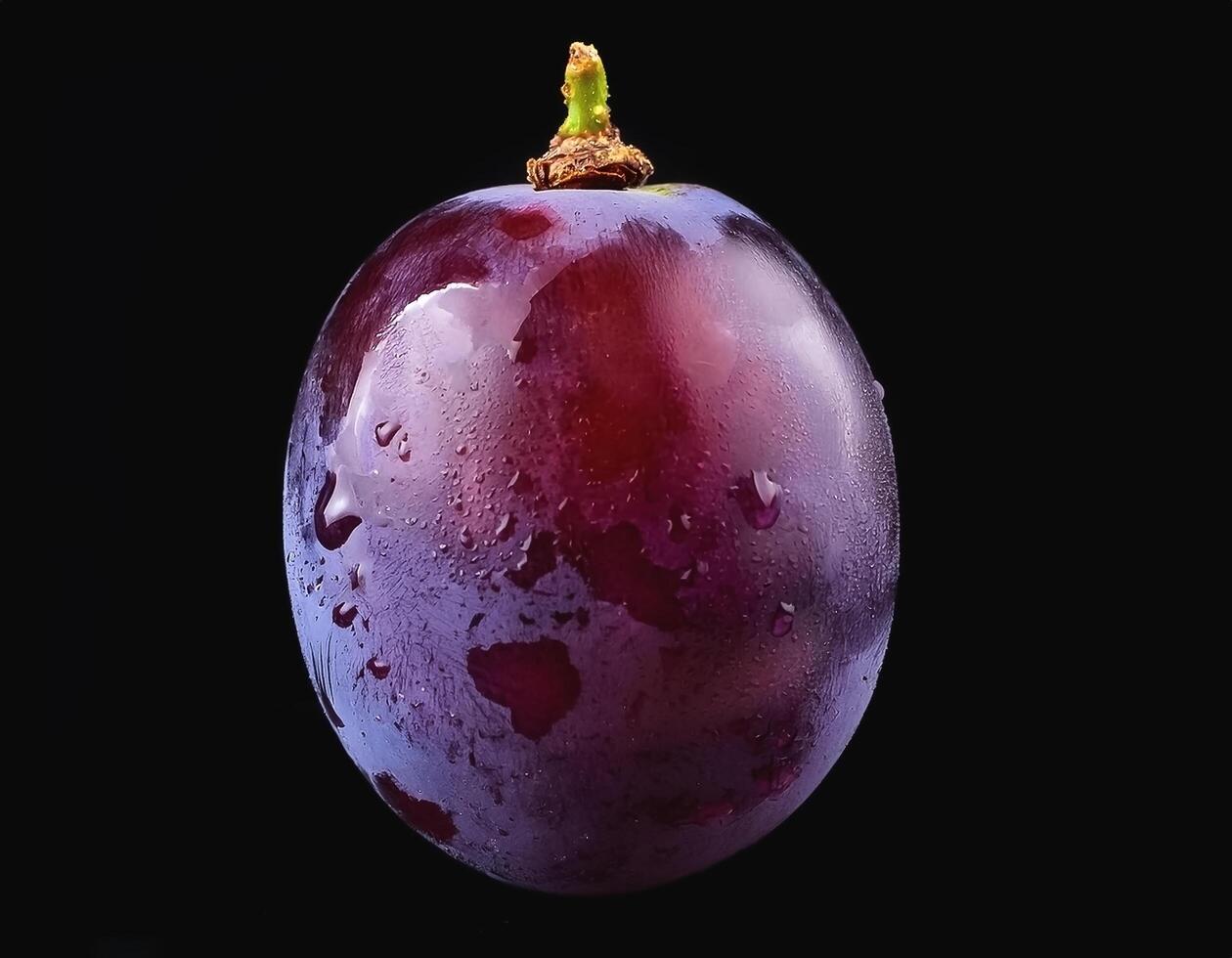 One purple grape isolated on a black background, showing the details of the skin and texture photo