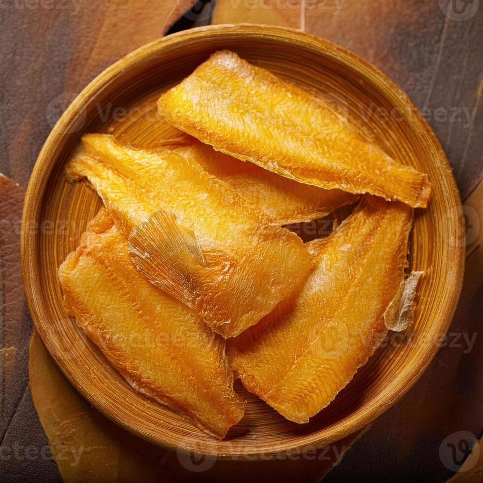 Dried fish in a wooden bowl on a table photo