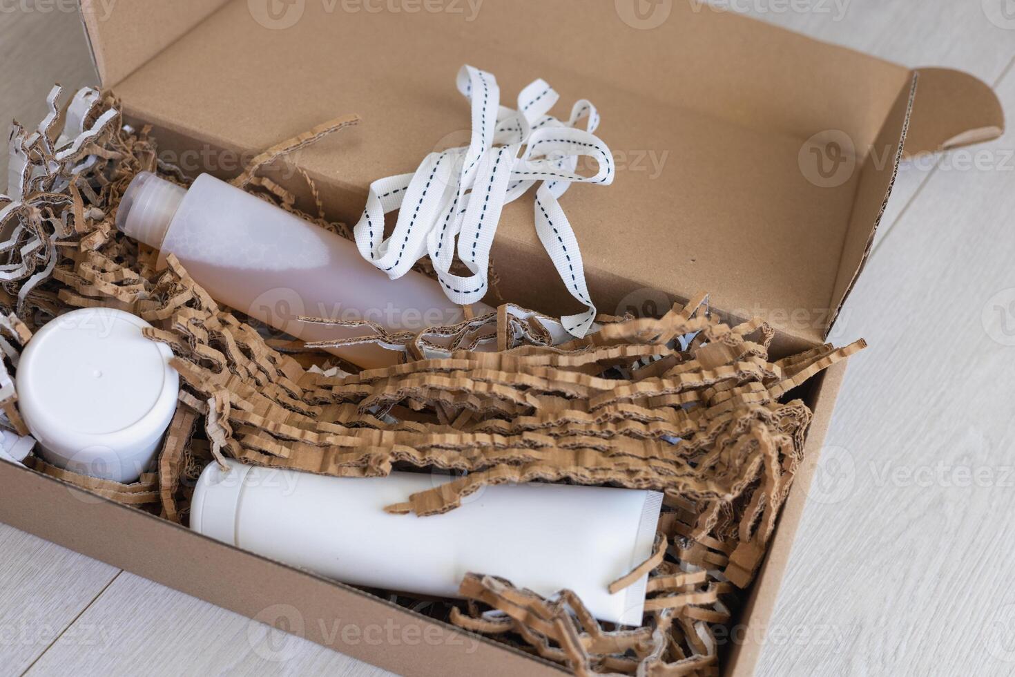 Eco-friendly packaging with personal care products in a cardboard box on a light floor photo