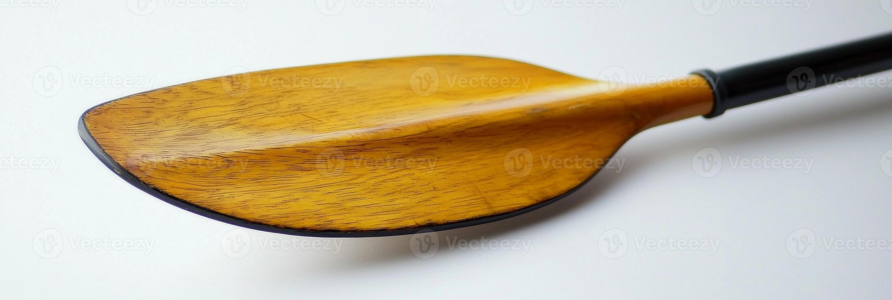 canoe paddle rests on a white background emphasizing its unique blade shape and handle grip. Soft shadows create a simplistic visual appeal perfect for water sports enthusiasts. photo