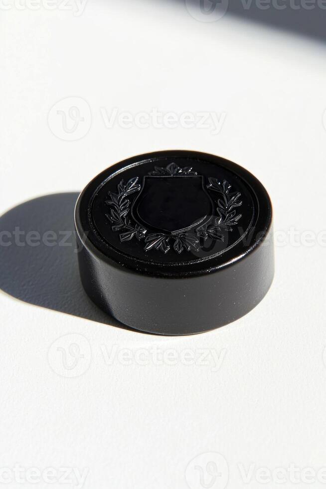 close up displays a hockey puck with a textured surface emphasizing its embossed logo against a bright white background offering a minimalist aesthetic. photo