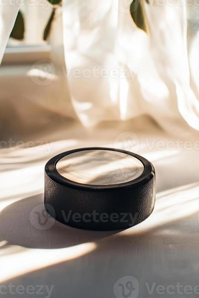 close up features a hockey puck with a textured surface and an embossed logo set against a white background with bright lighting and subtle shadowing showcasing its design. photo