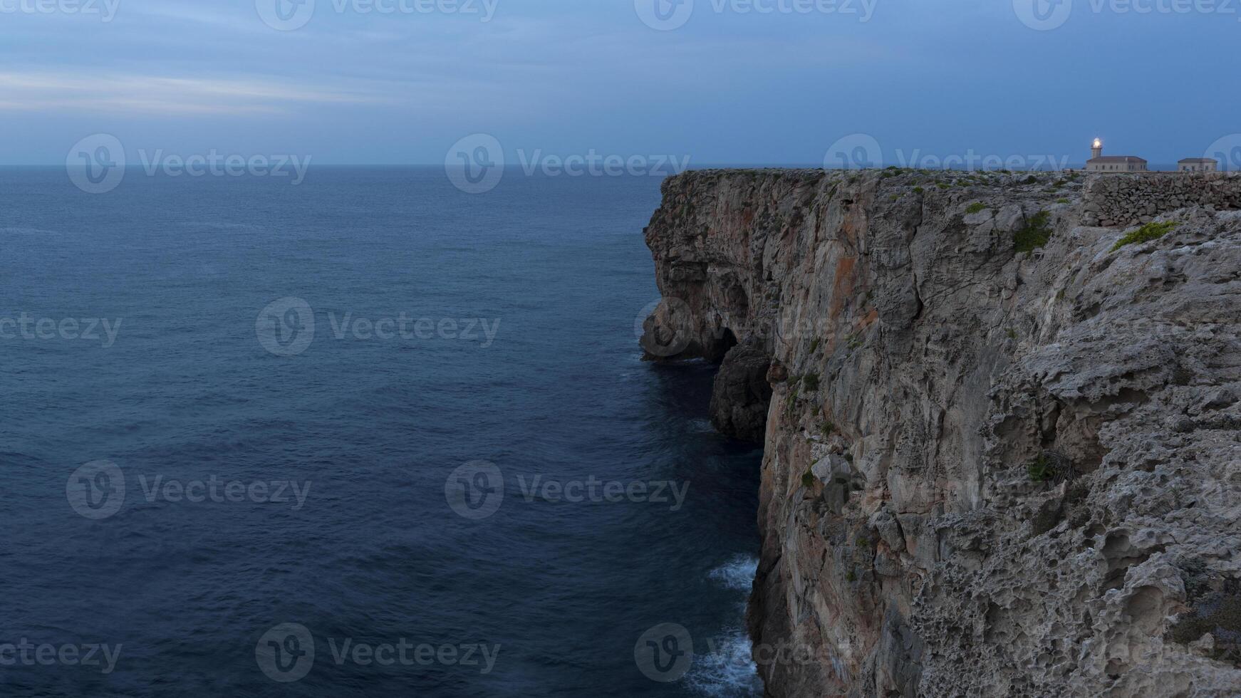 A cliff with a lighthouse on top photo