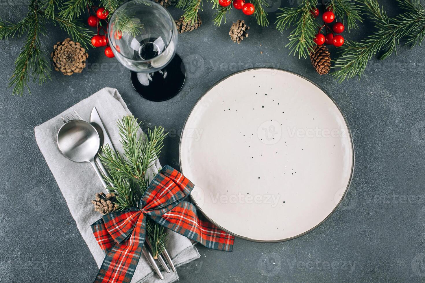 Christmas table setting on blue table. White plate and silver utensils. Festive holiday decoration photo