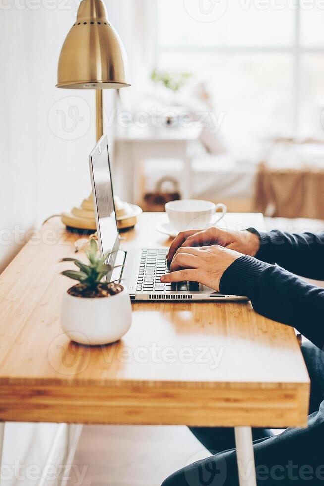 Businessman working on laptop at home office. Man watching online webinar. Remote work concept photo