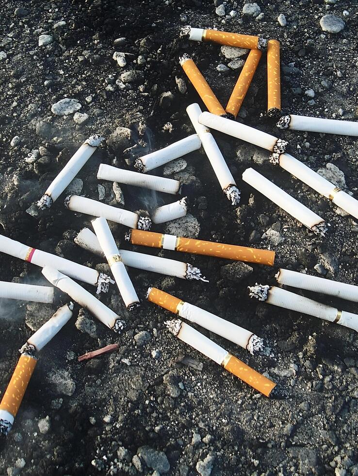 Unhealthy habit Tobacco cigarette ash waste on the ground photo