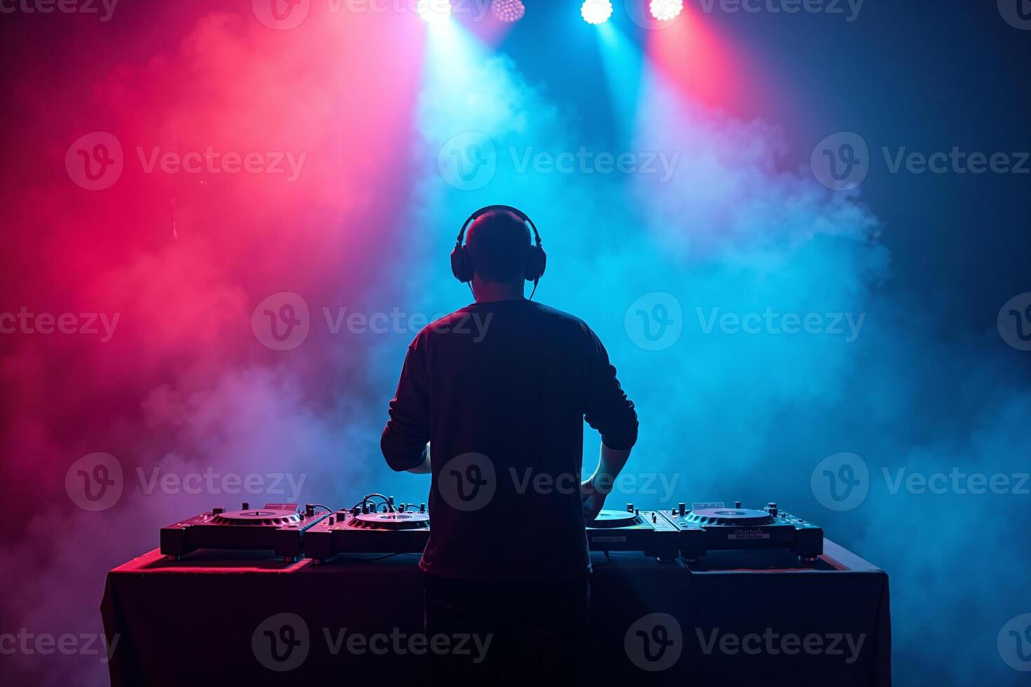 D.J. man standing in concert hall with smoke and colorful light enjoy music festival photo