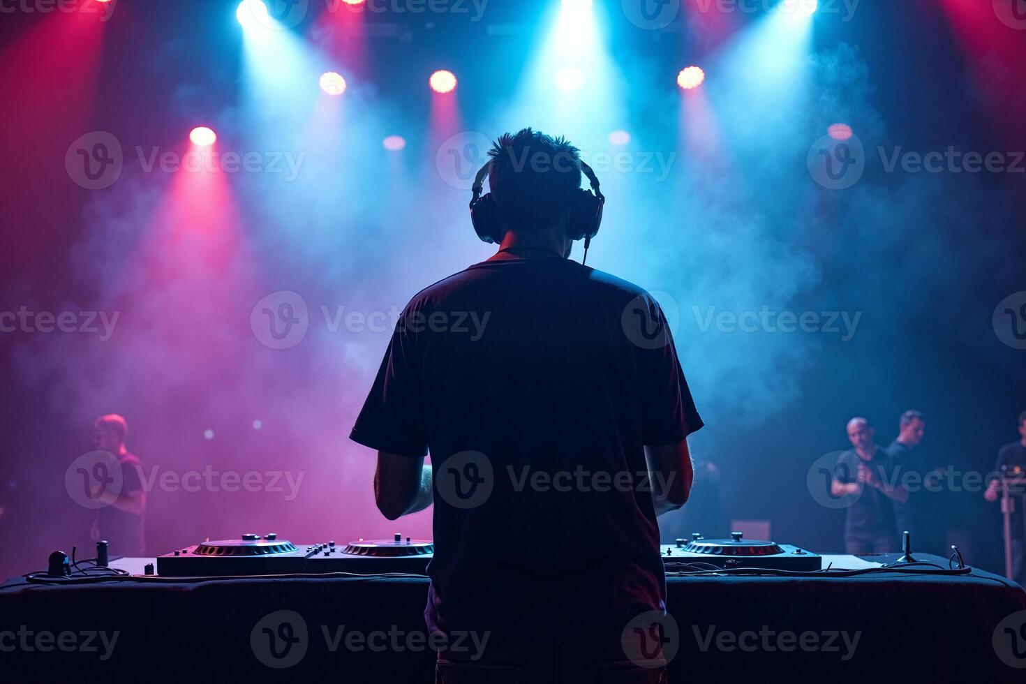 D.J. man standing in concert hall with smoke and colorful light enjoy music festival photo