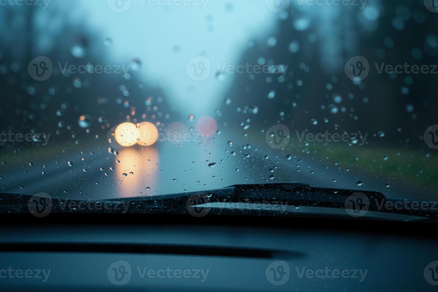 windscreen of car with rain drop water at night photo
