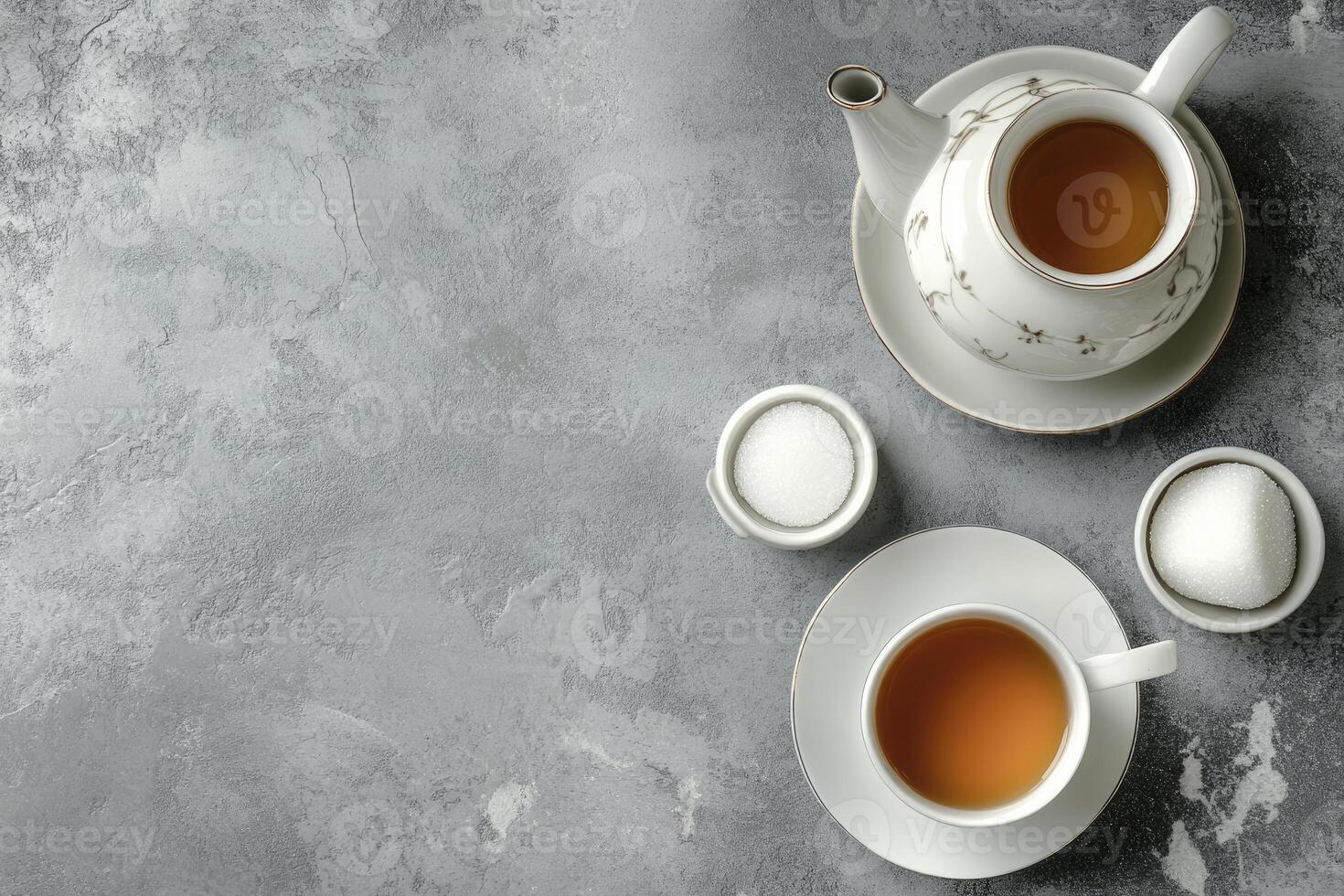 Two cups of tea and a bowl of tea on a gray background photo