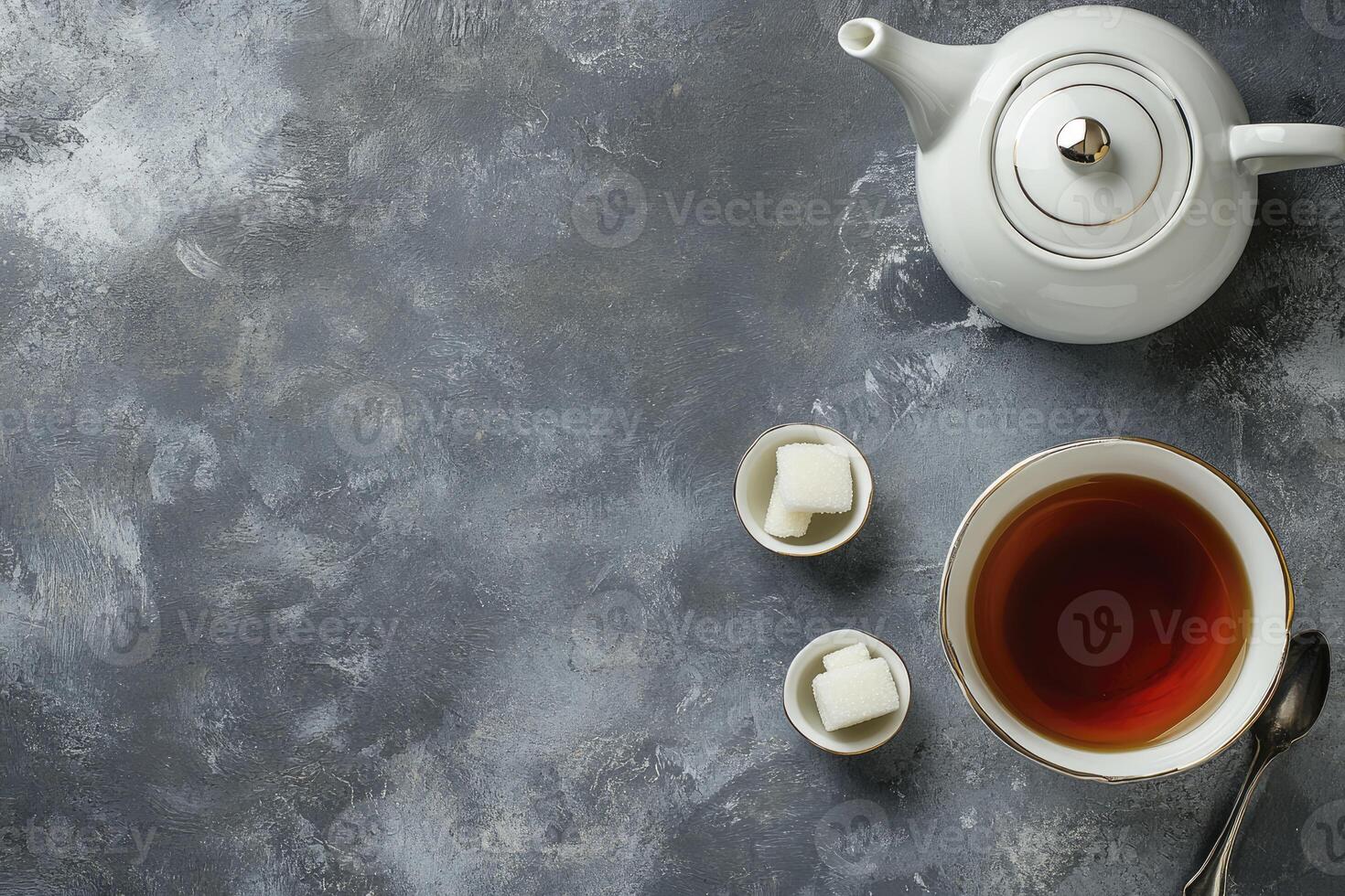 A cup of tea and sugar cubes on a grey background photo