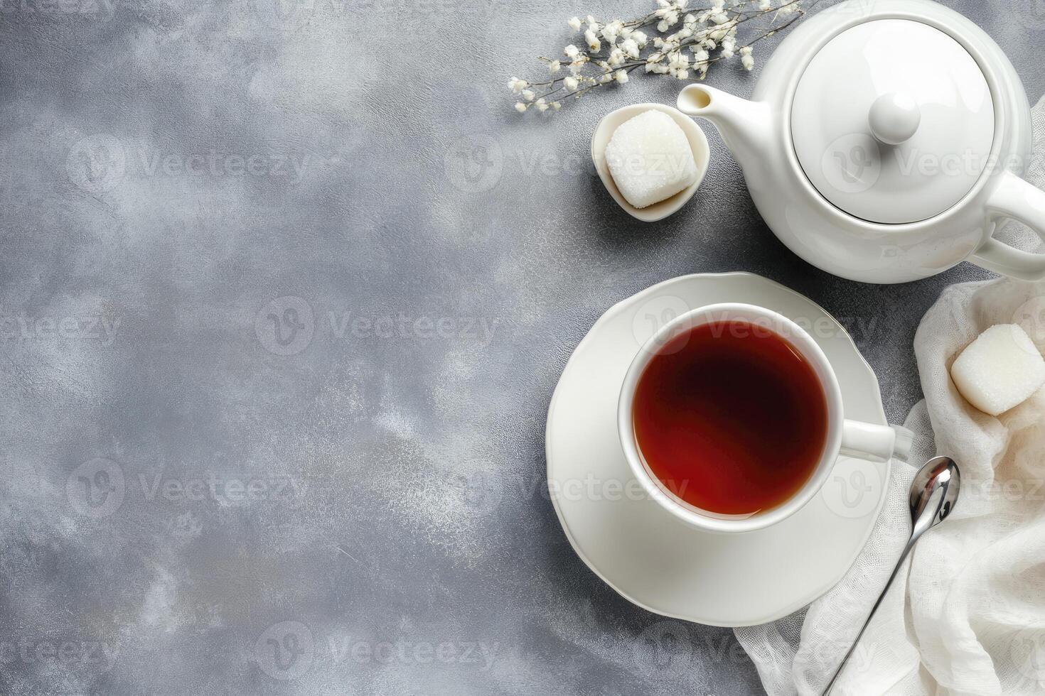 A cup of tea and a spoon on a grey background photo
