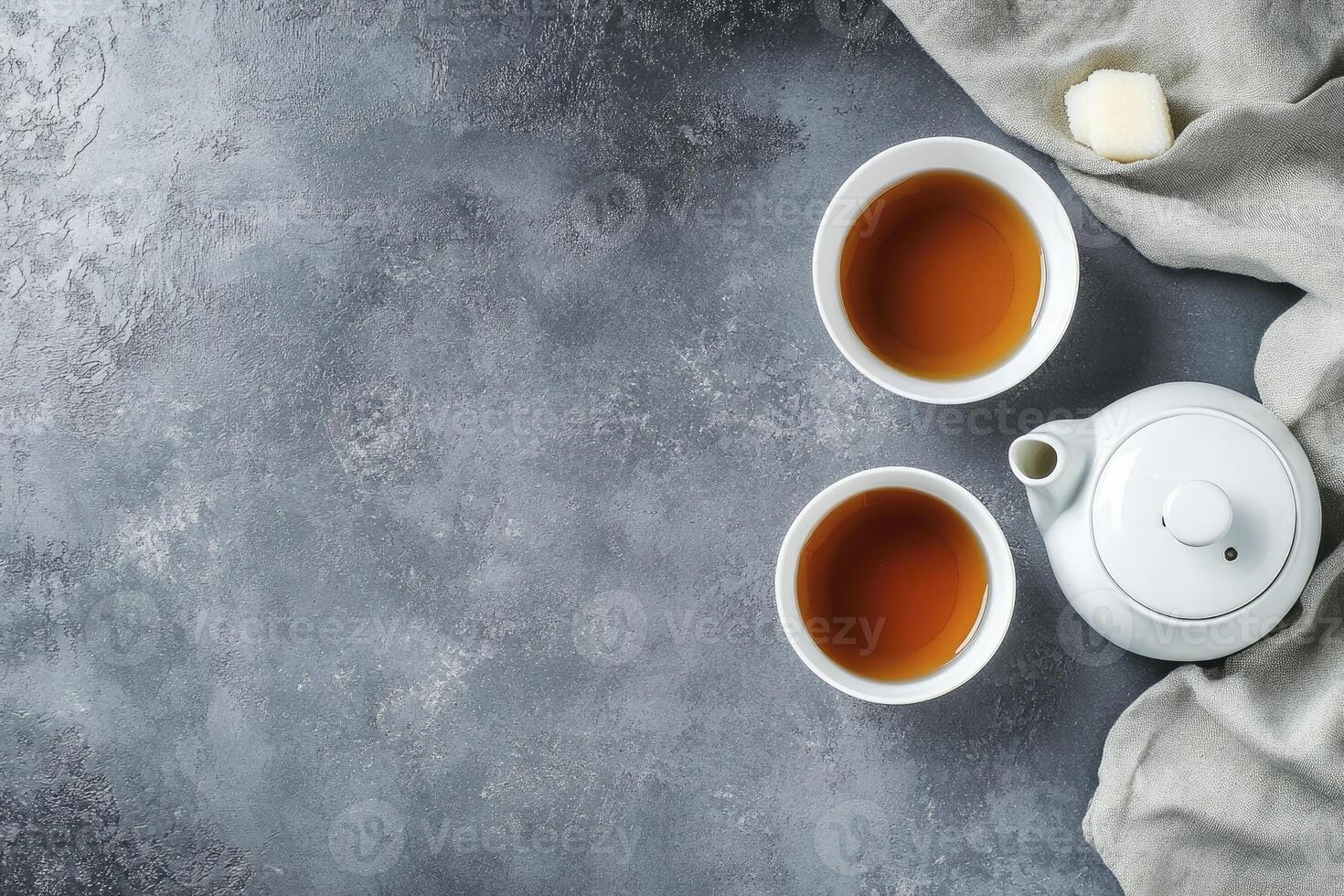 Two cups of tea and a teapot on a gray background photo