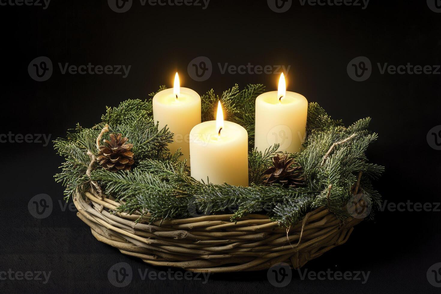 Three candles are lit in a wreath with pine cones photo