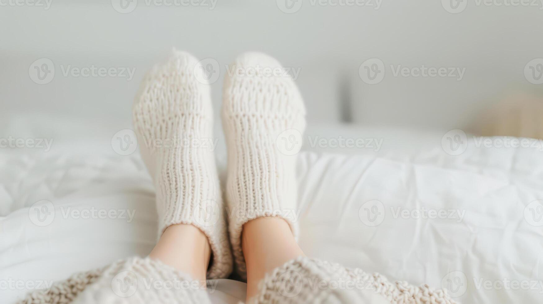 A person wearing white socks on a bed photo
