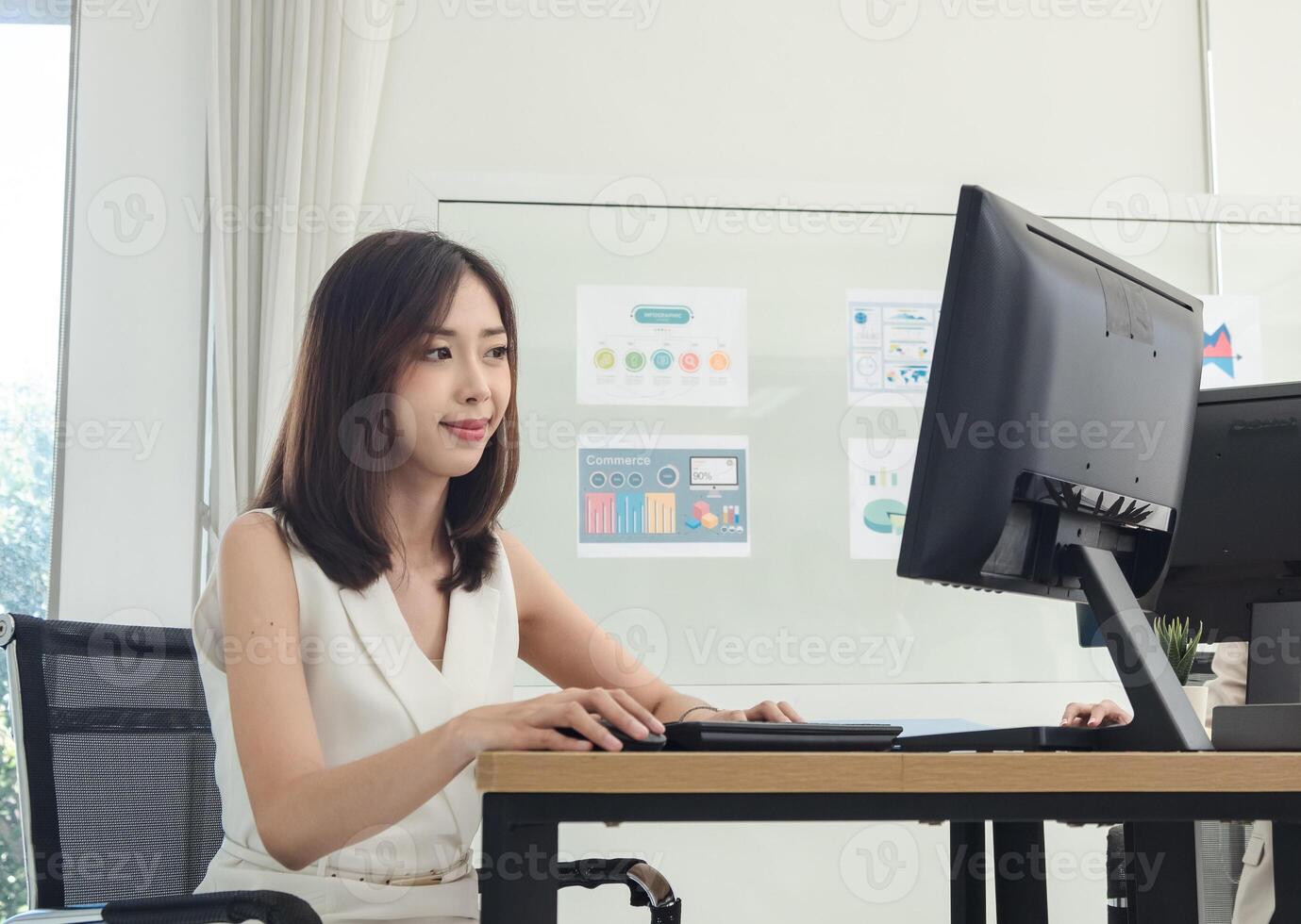 Manager employee woman girl asian one person smile happy enjoy sitting chair on desk looking hand holding notebook laptop ready for business working job online sale inside the room office company photo
