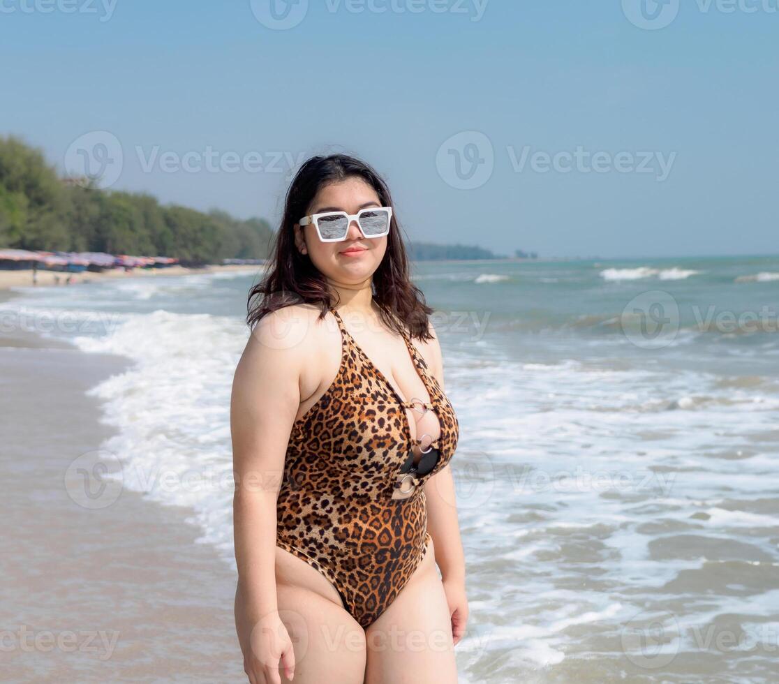 Woman young asian fat chubby cute beautiful smile happy fun enjoy relax fredom bikini swimwear body sexy front view sea beach white sand clean blue sky calm nature ocean wave water travel on holiday photo