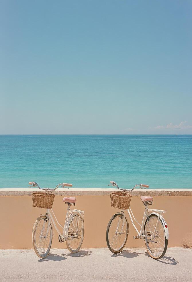 Two vintage bicycles with wicker baskets overlooking a serene ocean view by the beachside walkway photo