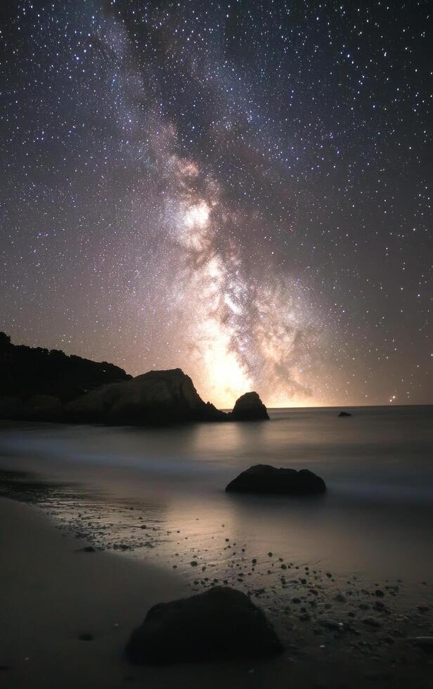Starlit beach view with the Milky Way above, captured during a clear night by the ocean photo