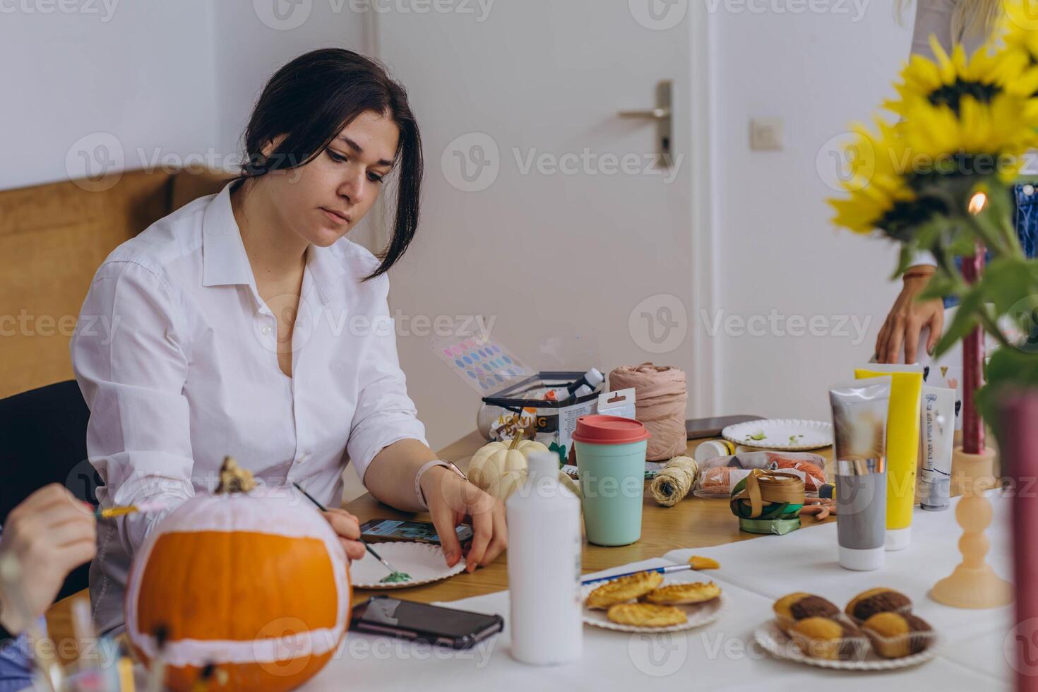 Children and adults painting pumpkins for Halloween, enjoying a fun and creative activity together. photo
