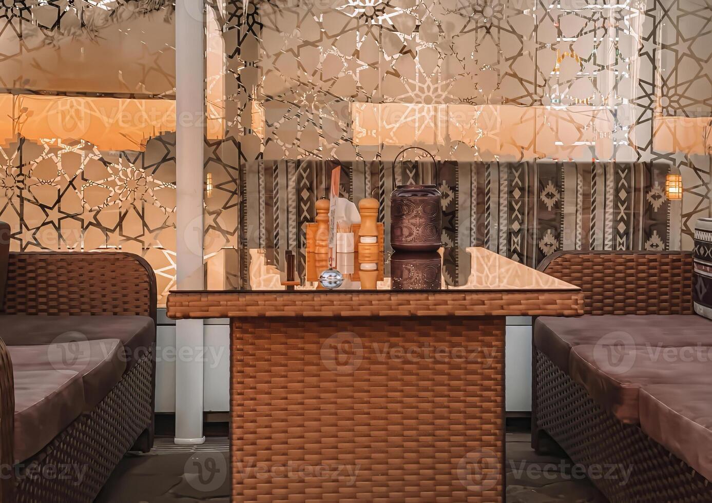 Relaxing living room scene. a wicker coffee table with a glass top and a plush couch positioned beneath a window photo
