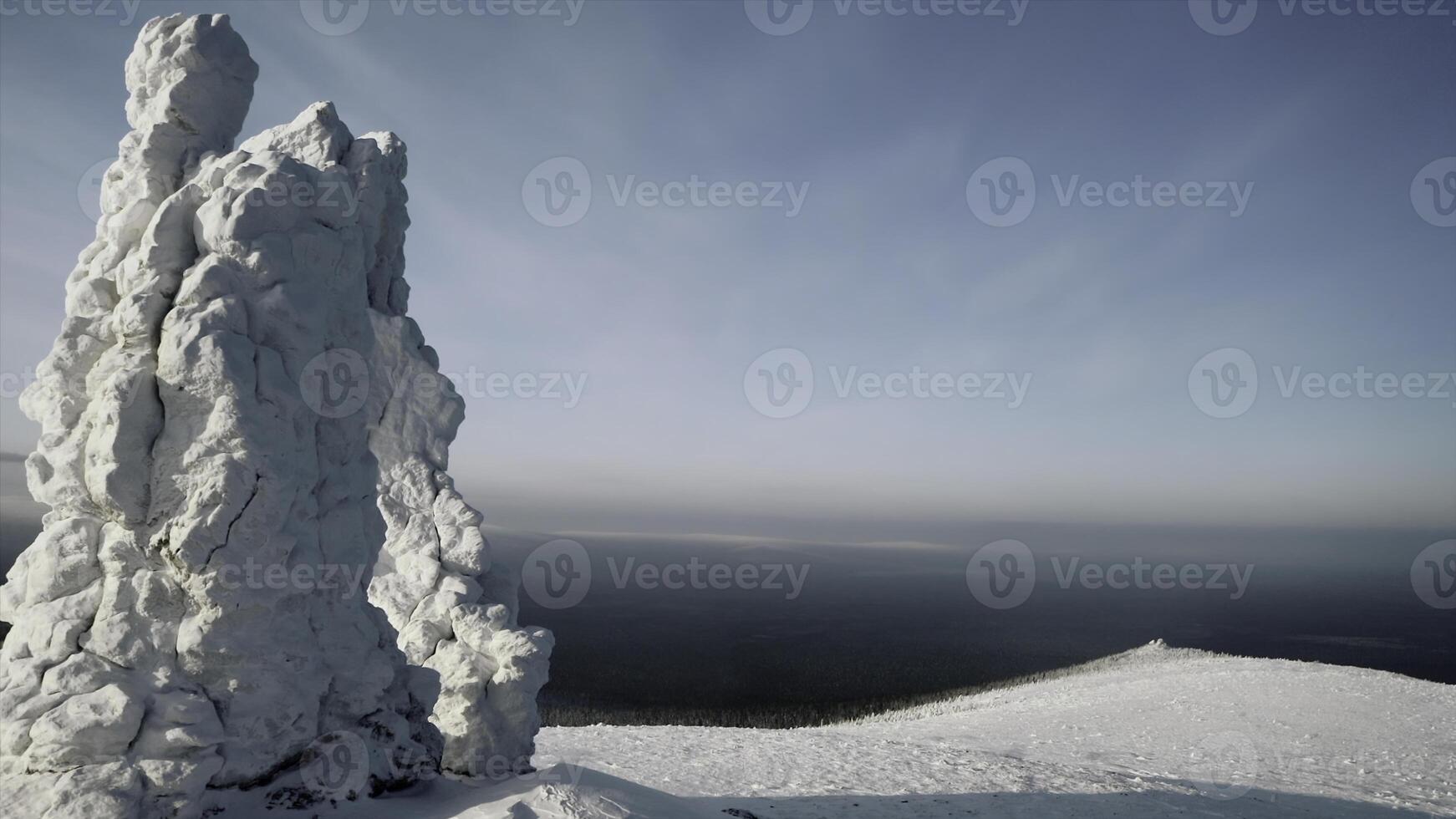 Winter mountain view from a bird's-eye view. Clip.Big mountains under snow and ice on a snowy mountain and a green forest with tall trees is visible below. photo