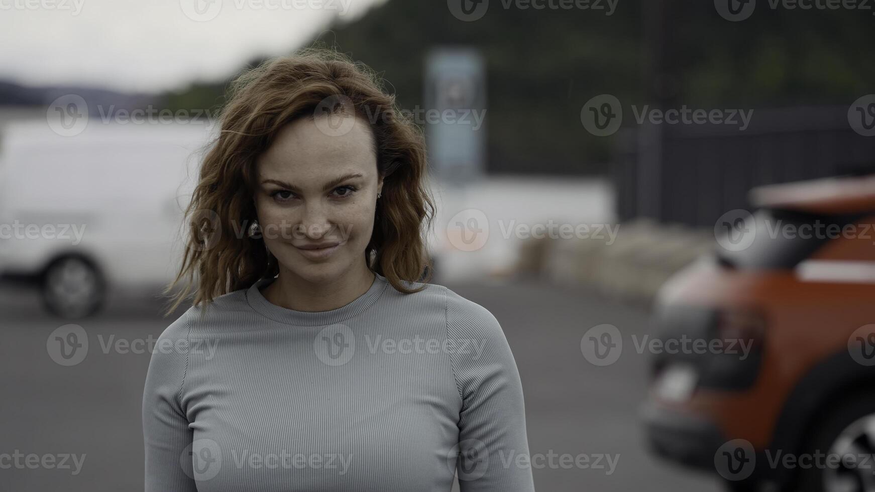 Beautiful walking woman. Action.A young model with wavy red wavy hair walking with a flying gait in the park. photo