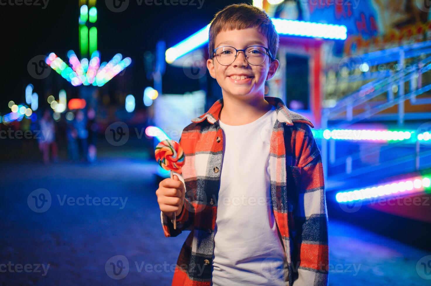 A handsome and happy boy is having fun in the amusement park photo