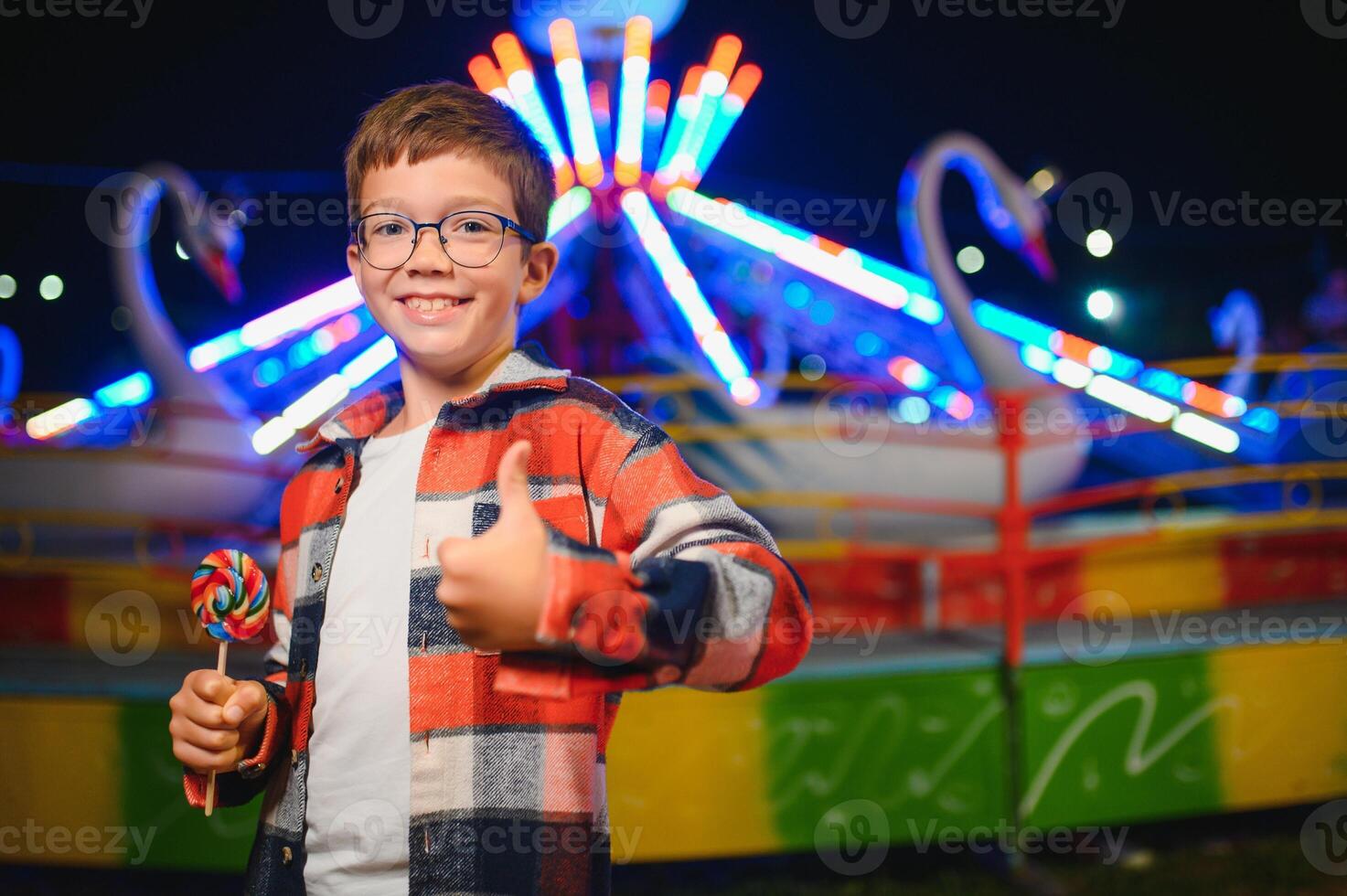 A handsome and happy boy is having fun in the amusement park photo