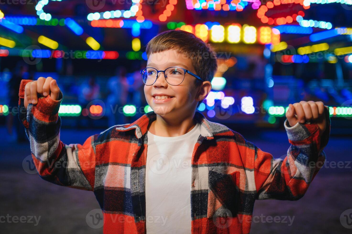 A handsome and happy boy is having fun in the amusement park photo