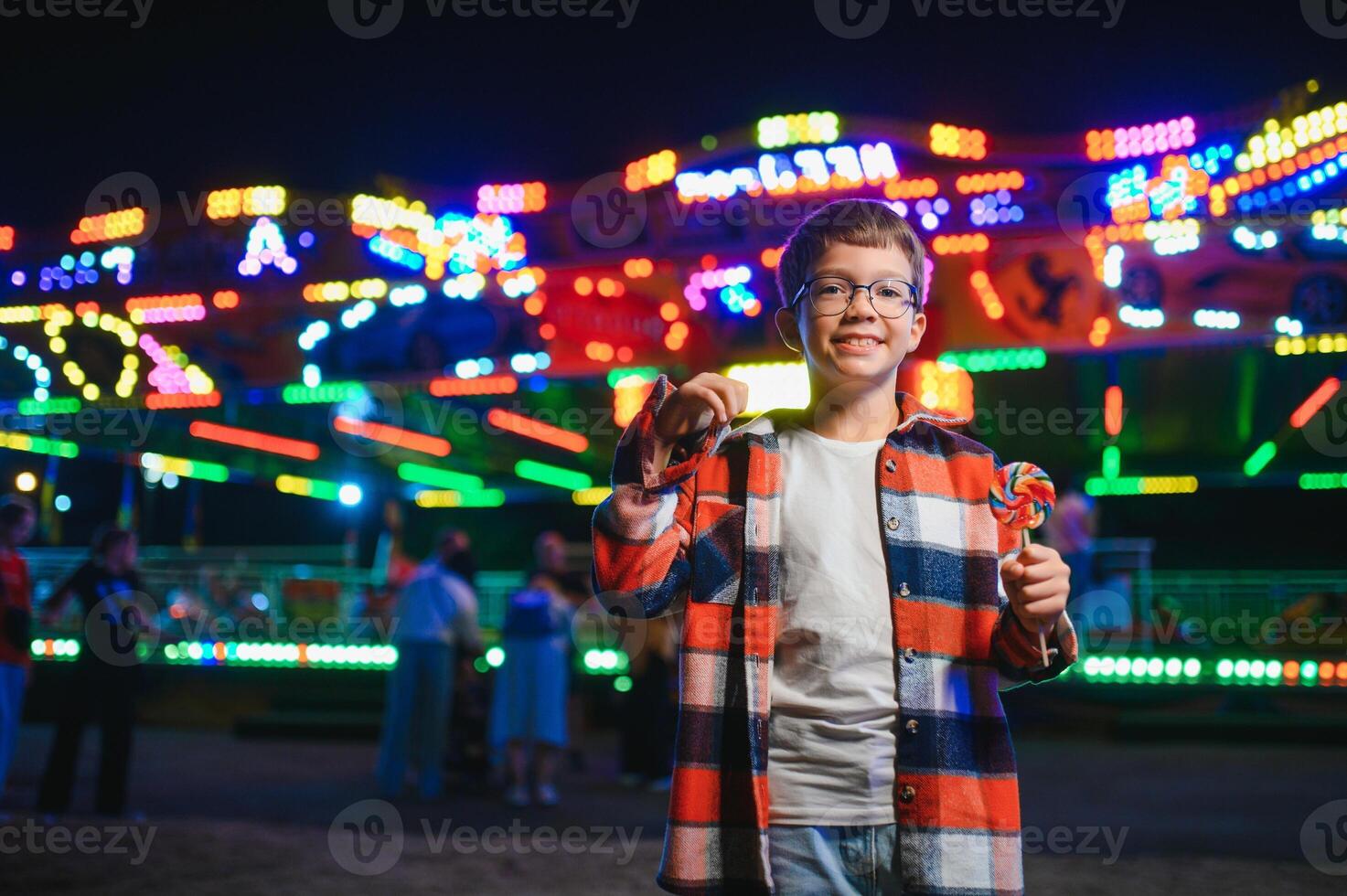 A handsome and happy boy is having fun in the amusement park photo