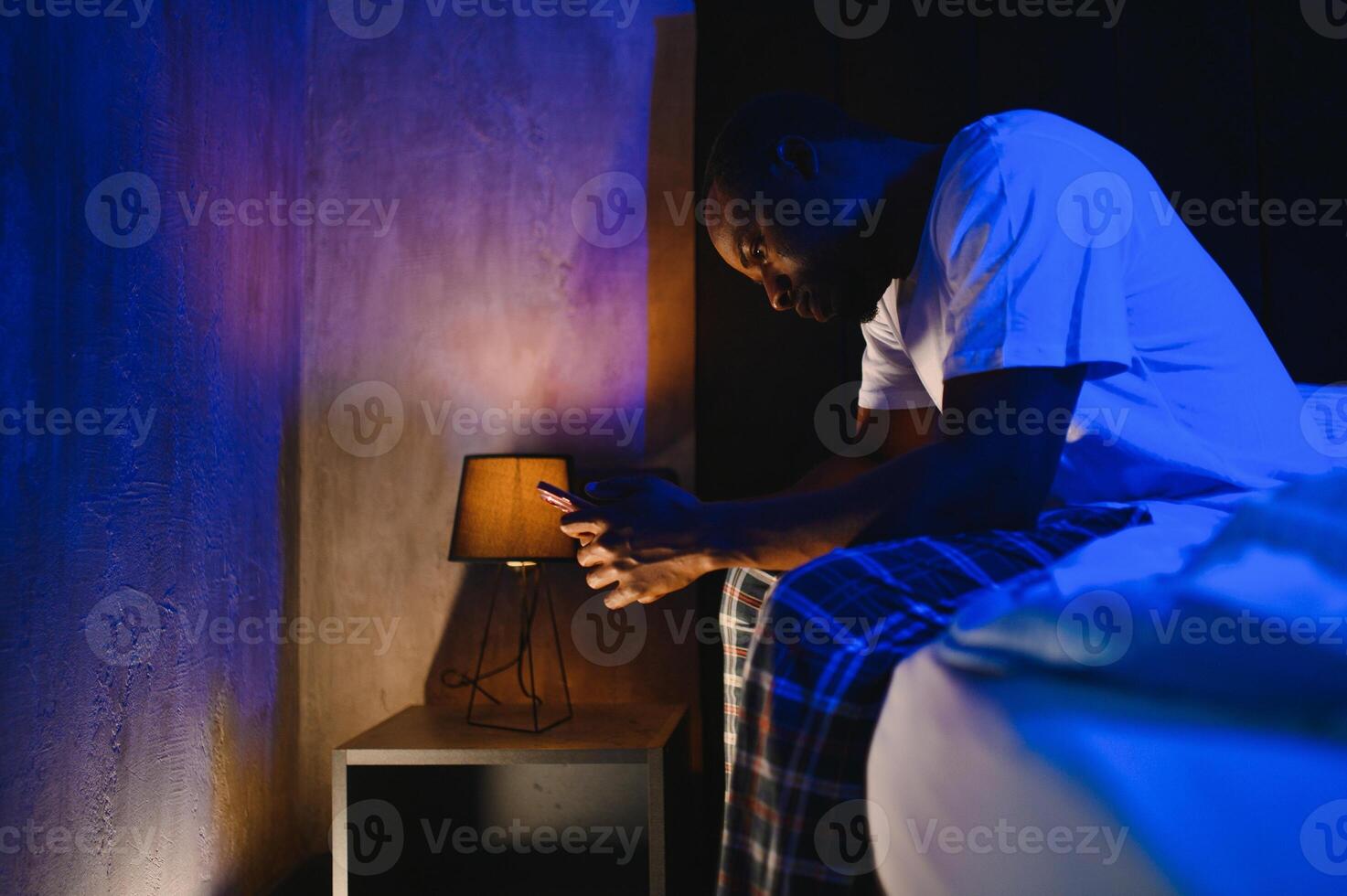 Worried man with a beard in bed. Sleepless young male looking pensive in a cozy bedroom with soft lighting photo